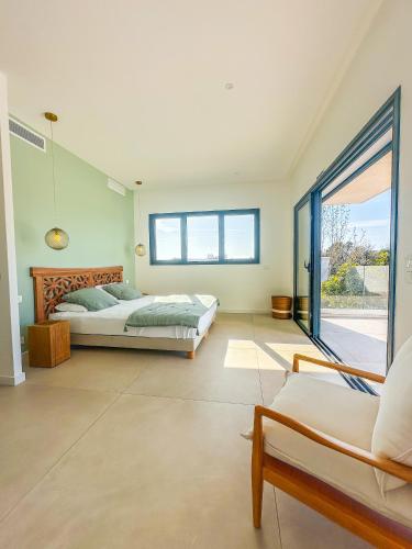 une chambre avec un lit et une grande fenêtre dans l'établissement Villa Alimea San Ciprianu, à Cirendinu