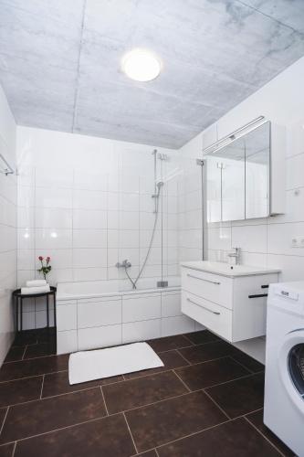 a white bathroom with a tub and a sink at Terrassenwohnung 6 Nachhaltige Kühlung über Erdsonde und Fussbodenkühlung in Klaus
