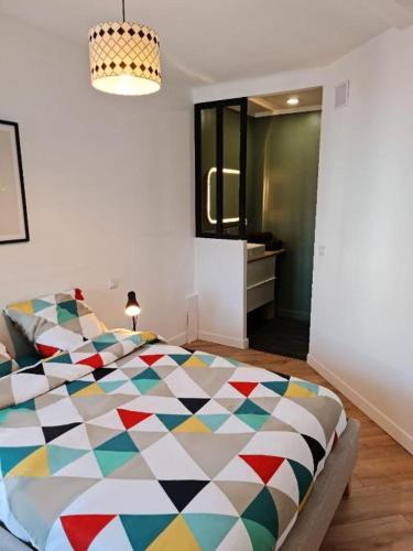 a bedroom with a colorful comforter on a bed at Le ScottmanHouse - Appartement privé - Centre ville - Gare - Wi-Fi in Arras
