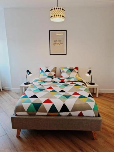 a bedroom with a bed with a colorful comforter at Le ScottmanHouse - Appartement privé - Centre ville - Gare - Wi-Fi in Arras