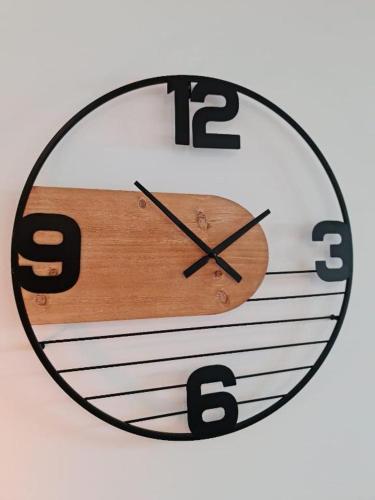 a clock is hanging on a white wall at Le ScottmanHouse - Appartement privé - Centre ville - Gare - Wi-Fi in Arras