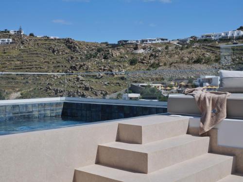 a set of stairs on a balcony with a view of a hill at Iria Blue Mykonos in Platis Yialos Mykonos