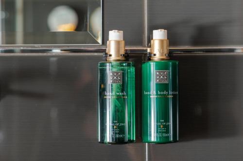 two green bottles are sitting on a shelf at Marmont Heritage Hotel in Split