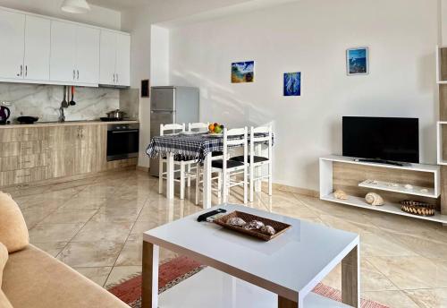 un soggiorno con un tavolo e una cucina di Corfu View Apartment a Sarandë