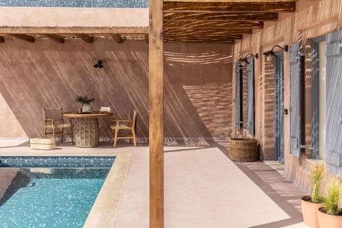 a patio with a table and a swimming pool at Terracotta Fiscardo Villas in Fiskardho