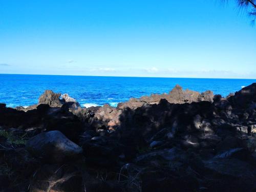 un gruppo di rocce sulla riva dell'oceano di Comme chez vous a Saint-Joseph