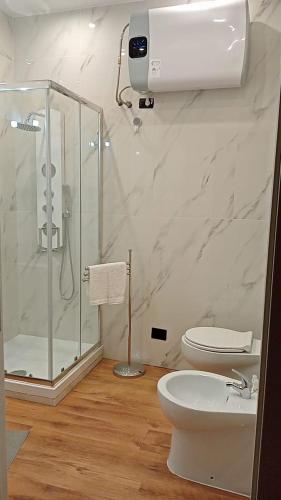 a white bathroom with a shower and a toilet at Francia Suite in Rome