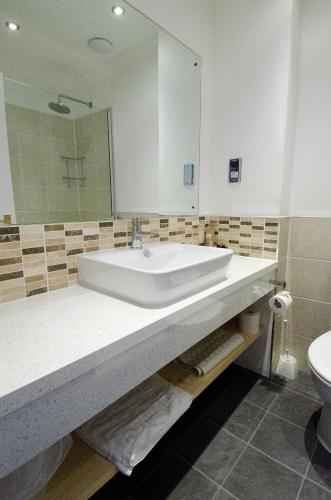 a bathroom with a sink and a mirror and a toilet at Seacote Hotel in St Bees