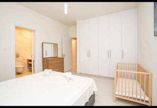 a white bedroom with a bed and a bathroom at Protaras The Icon 103 at Mythical Seas in Paralimni