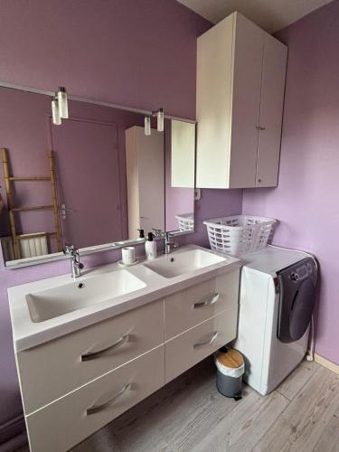 La salle de bains est pourvue d'un lavabo et d'un lave-linge. dans l'établissement Appartement lumineux à 5 min de la plage, à Cabourg