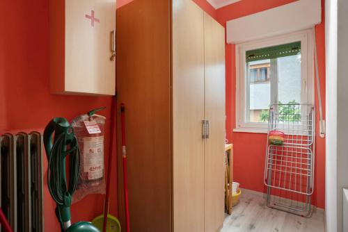 a kitchen with orange walls and a window at Appartamento Marconi 35 Pergine in Pergine Valsugana