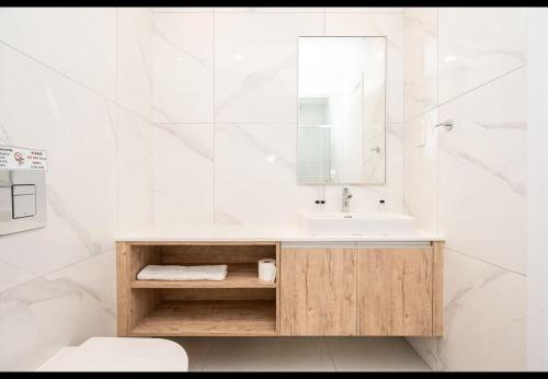 a white bathroom with a sink and a mirror at Protaras The Icon 103 at Mythical Seas in Paralimni