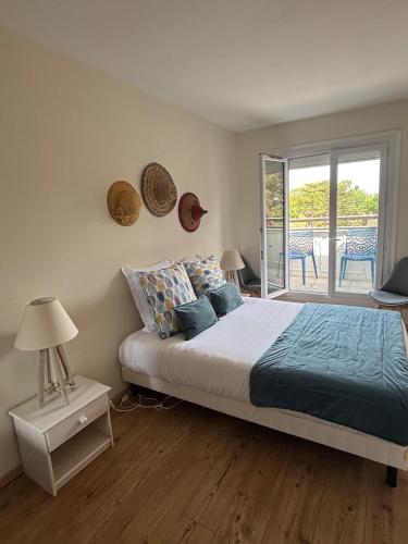 une chambre avec un lit et un balcon dans l'établissement Appartement lumineux à 5 min de la plage, à Cabourg