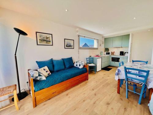 un salon avec un canapé bleu et une cuisine dans l'établissement Quiberon : Studio 4 pers, balcon, animaux admis, parking - FR-1-478-145, à Quiberon