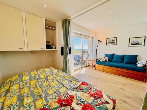 une chambre avec un lit et un canapé bleu dans l'établissement Quiberon : Studio 4 pers, balcon, animaux admis, parking - FR-1-478-145, à Quiberon