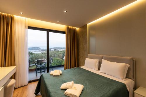 a bedroom with a bed with two towels on it at Diol Hotel Ksamil in Ksamil