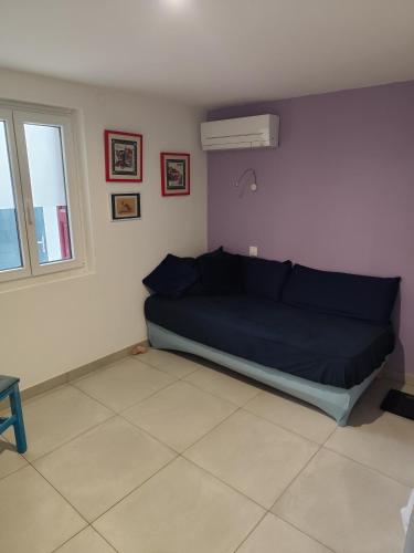 un canapé bleu dans une pièce avec une fenêtre dans l'établissement RDC a 2 pas du port, à Port-Vendres