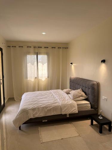 ein Schlafzimmer mit einem großen Bett vor einem Fenster in der Unterkunft Duplex familial in Lomé