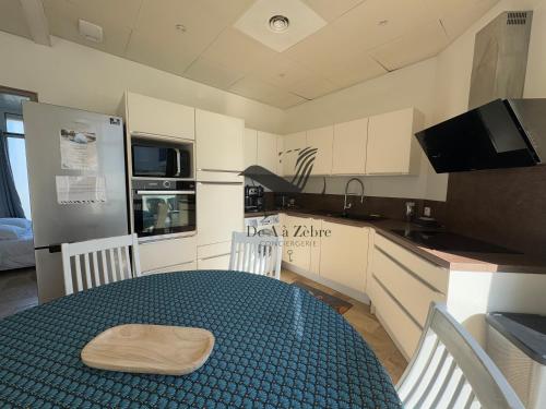 - une cuisine avec une table et un bol en bois dans l'établissement Magaly - Situé à deux pas de la plage, à Châtelaillon-Plage