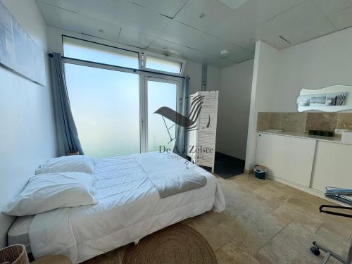 une chambre avec un lit et une grande fenêtre dans l'établissement Magaly - Situé à deux pas de la plage, à Châtelaillon-Plage