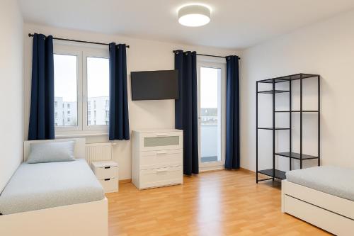 1 dormitorio con 2 camas, vestidor y ventanas en StayInn Halle (Saale), en Nietleben