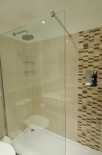 a bathroom with a glass shower with a toilet at Seacote Hotel in St Bees