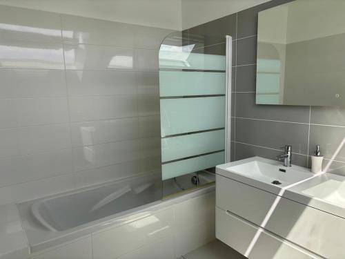 une salle de bain blanche avec une baignoire et un lavabo dans l'établissement Maison vue mer, à Saint-Jacut-de-la-Mer