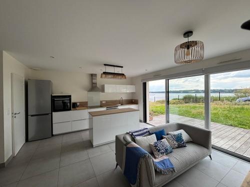 un salon avec un canapé et une cuisine dans l'établissement Maison vue mer, à Saint-Jacut-de-la-Mer