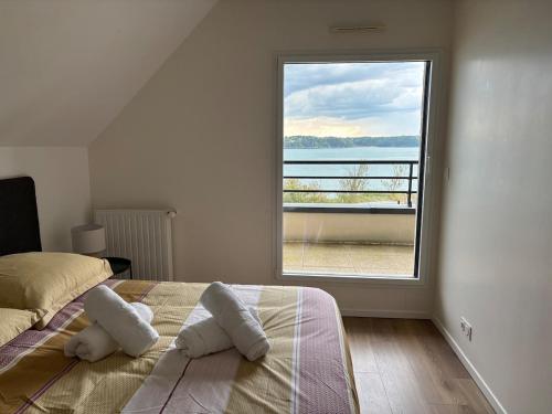 une chambre avec un lit et une grande fenêtre dans l'établissement Maison vue mer, à Saint-Jacut-de-la-Mer