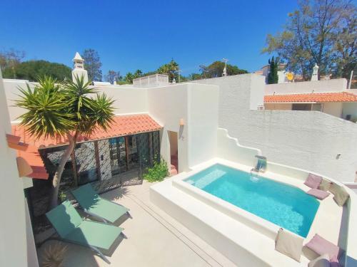 a villa with a swimming pool and two chairs at Villa Esperança in Porches