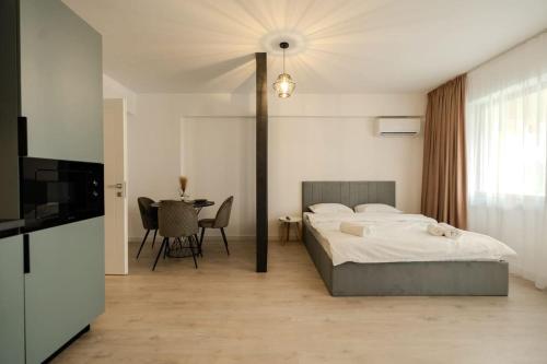 a bedroom with a bed and a table with chairs at Blvd Ivory Pipera ap 9b7 in Bucharest
