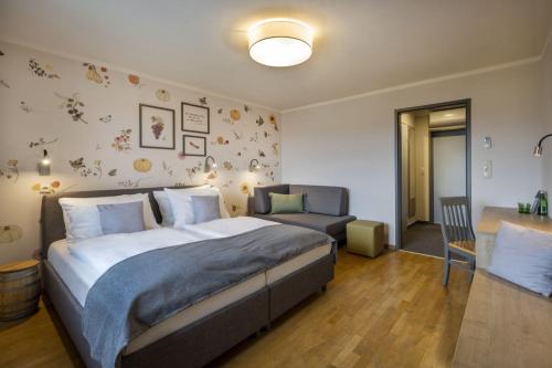 a bedroom with a bed and a chair and a table at JUFA Hotel Deutschlandsberg in Deutschlandsberg
