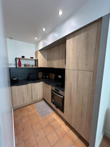 - une cuisine avec des placards en bois et une cuisinière dans l'établissement Beautiful F2 with large terrace & air conditioning, à Avignon