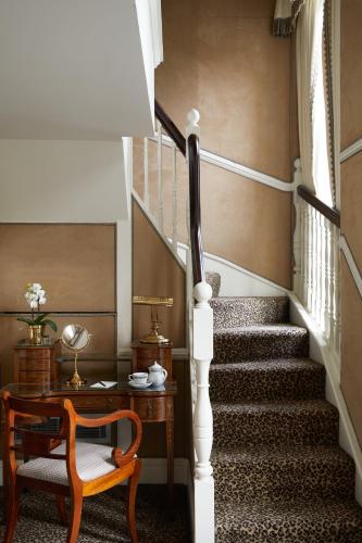 a staircase with a table and a chair and a stair case at Milestone Hotel Kensington in London