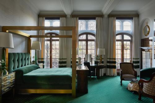 a bedroom with a bed and a desk and windows at Milestone Hotel Kensington in London