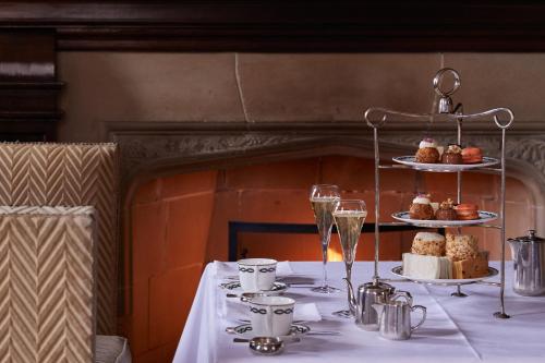 a table with a white table cloth with cakes and wine glasses at Milestone Hotel Kensington in London