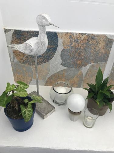 a statue of a bird on a table with plants at A Castelana de Cea in Cea