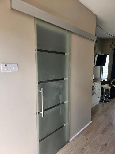 a glass refrigerator in a room with a wall at The Cosy Nest - An Nead Cluthar in Kilkenny