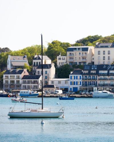 a sail boat in the water in front of a city at Le Goyen in Audierne