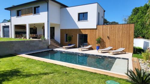 une maison avec une piscine devant dans l'établissement Villa des Embruns Entre Hossegor et Biarritz, à Boucau