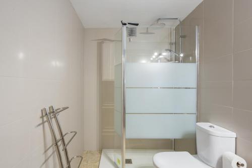 Un baño con inodoro y ducha de cristal. en Daimuz Holidays, en Daimuz