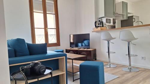 a living room with a blue couch and a tv at Apartment for 6 people CDG and Asterix parc in Survilliers