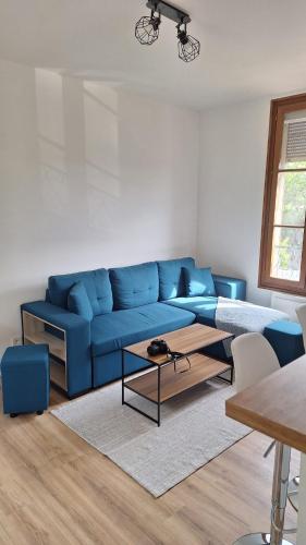 a living room with a blue couch and a table at Apartment for 6 people CDG and Asterix parc in Survilliers