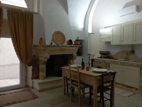a kitchen with a table and a fireplace at B&B Sara in Tuglie