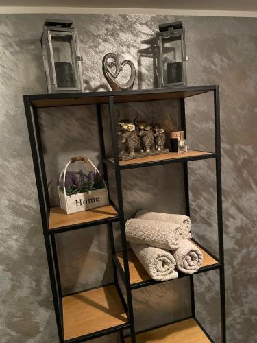 a black shelf with towels and a basket on it at Kunderi apartment with sauna in Rakvere