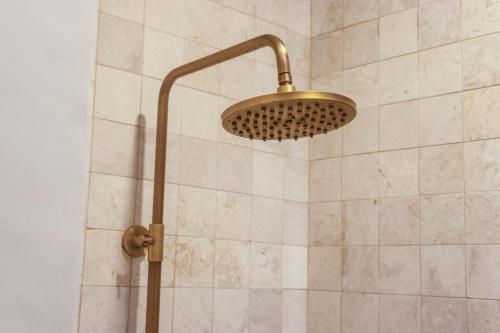 a shower with a shower head in a bathroom at Luxurious Arakana Villa with Pool in Jimbaran