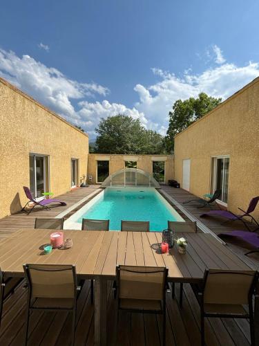un patio avec une table et une piscine dans l'établissement Belle villa - Entre Mer et Montagnes, à Corneilla-de-Conflent