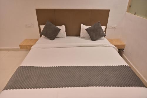 a bedroom with a large bed with a wooden headboard at Nirvana Bliss Prayagraj in Prayagraj