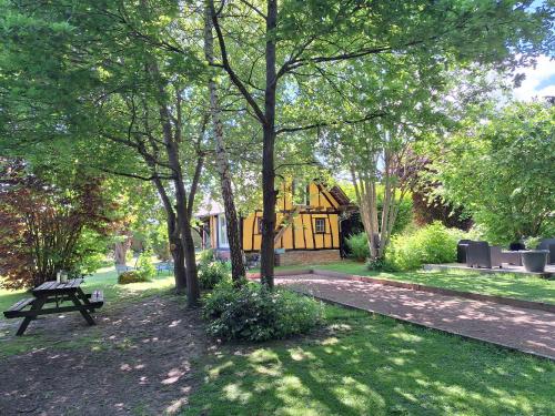 a park with a bench and a tree at La petite maison in Le Bosc-Roger-en-Roumois