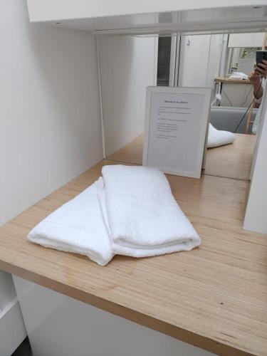 une serviette blanche assise au-dessus d'un comptoir dans l'établissement AU COEUR de Paris AU PIED de notre Dame Studio equipe salle de bains wc calme clair type cabine clim ascenseur, à Paris